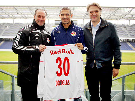 Salzburgs Trainer Huub Stevens, Neuzugang Douglas da Silva und der sportliche Leiter von Red Bull Dietmar Beiersdorfer halten da Silvas neues Trikot in die Kamera