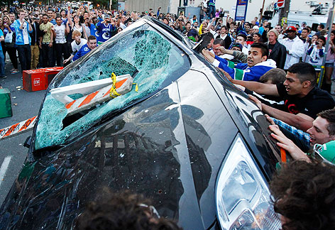 Canucks-Fans schmeißen ein beschädigtes Auto um