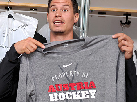 © GEPA/Amir Beganovic Oliver Setzinger hält ein Shirt mit der Aufschrift "Property of Austria Hockey"