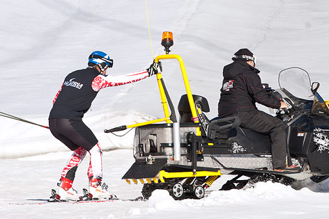 © APA/EXPA/Johann Groder Benjamin Raich hält sich an Schneemobil fest