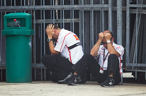 © APA/EPA/Ahmad Yusni Zwei Mitglieder des MotoGP-San-Carlo-Honda-Gresini-Teams sitzen am Boden vor dem medizinischen Aufnahmezentrum in Sepang