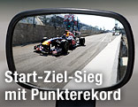 In einem Rückspiegel ist Rennfahrer Sebastian Vettel zu erkennen