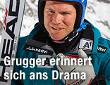 Hans Grugger mit Skiern und Skihelm redet und gestikuliert