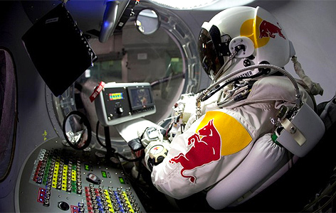 © Redbullstratos.com Felix Baumgartner mit Druckanzug sitzt in einer kleinen Kapsel mit Bedienelementen