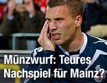 Lukas Podolski hält sich die Wange