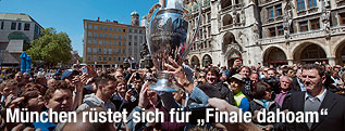 Menschenmenge umringt den Champions League Pokal