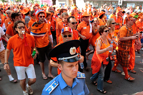 © Reuters/Vasily Fedosenko Ein Polizist begleitet niederländische Fans auf dem Marsch in Metalist-Stadion
