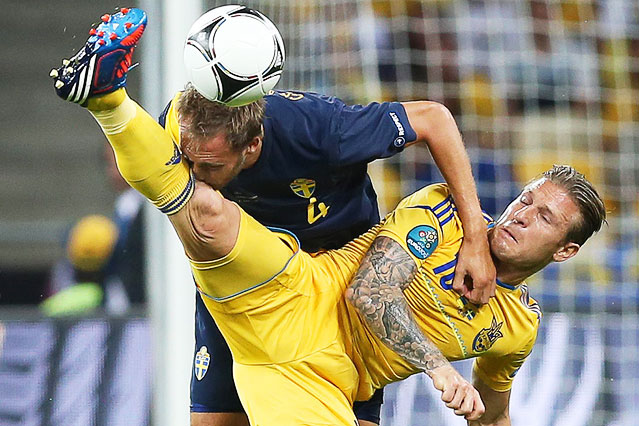 © APA/EPA/Srdjan Suki Schwedens Andreas Granqvist macht Bekanntschaft mit dem Oberschenkel von Andrej Woronin (UKR)
