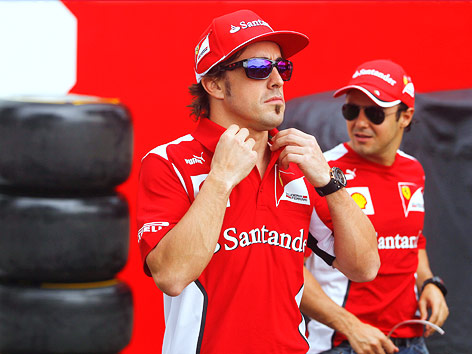 Fernando Alonso (Ferrari) richtet sich seinen Polokragen zurecht, im Hintergrund sein Teamkollege Felipe Massa