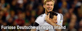 Jubelnde Deutschland-Spieler Mesut Oezil und Per Mertesacker