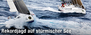 Das Segelschiff "One For The Road" bricht durch eine Welle