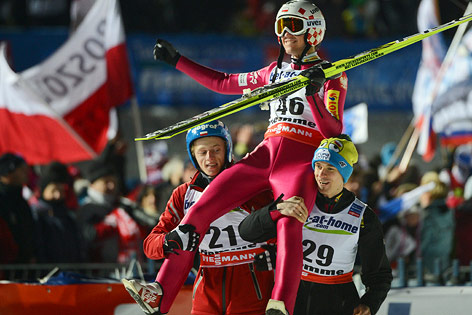 © APA/EPA/Hendrik Schmidt Kamil Stoch wird von Piotr Zyla und Dawid Kubacki auf den Schultern getragen