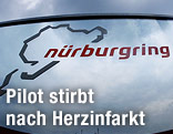 Dunkle Wolken spiegeln sich in einem Schild des Nürburgring