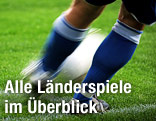 Beine eines Fußballers mit Ball