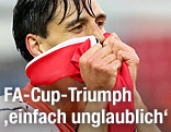 Paul Scharner (Wigan) hält sich lächelnd eine rot-weiß-rote Fahne ins Gesicht