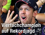 Sebatian Vettel streckt beim Jubeln vier Finger in die Luft