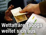 Geld wird im Wettb&uuml;ro &uuml;bergeben