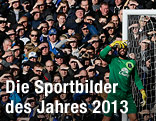 Everton-Torhüter Tim Howard und Fans schirmen ihr Gesicht gegen die tiefstehende Sonne ab