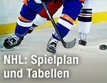 Füße von Eishockey-Spielern und Puck