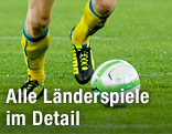 Beine eines Fußballers und Ball
