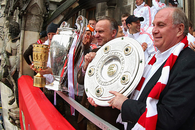 © Reuters/Alexander Hassenstein Hoeneß feiert 2013 mit dem FC Bayern das Triple und hält den Meisterteller in der Hand