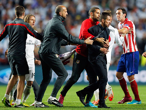 © AP/Daniel Ochoa de Olza Atletico coach Diego Simeone wird vom Atletico-Stab zurückgehalten