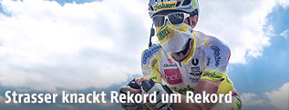 Christoph Strasser mit Mundschutz auf dem Rad