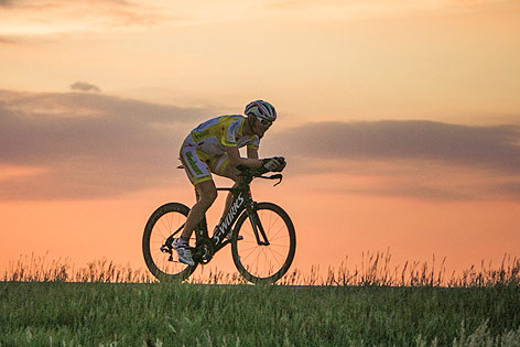 © Karelly/lupispuma.com Christoph Strasser bei Sonnenuntergang auf dem Rad