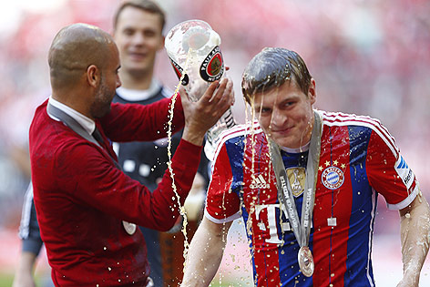 © Reuters/Michael Dalder Toni Kroos (Bayern) wird von Trainer Pep Guardiola mit Bier begossen