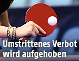 Hand mit Tischtennisschläger und Ball