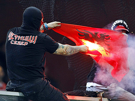 © Reuters/Alessandro Garofalo Serbischer Fan verbrennt albanische Fahne