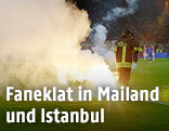Feuerwehrmann auf dem Spielfeld löscht Feuerwerkskörper