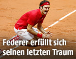 Roger Federer sitzt jubelnd am Boden