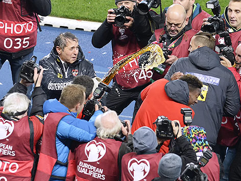 ÖFB-Teamchef Marcel Koller überschüttet David Alaba und Marko Arnautovic vor Fotografen mit Bier