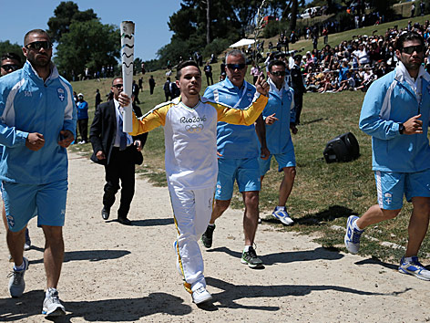 © Reuters/Alkis Konstantinidis Der erste Läufer trägt die Olympischen Flamme