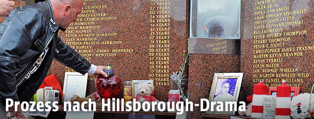 Ein Mann stellt eine Kerze an die Gedenkstätte vor dem Hillsborough-Stadion in Sheffield