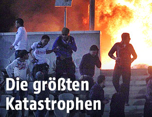 Ägyptische Fußballfans rennen von einer brennenden Zuschauertribüne in Port Said